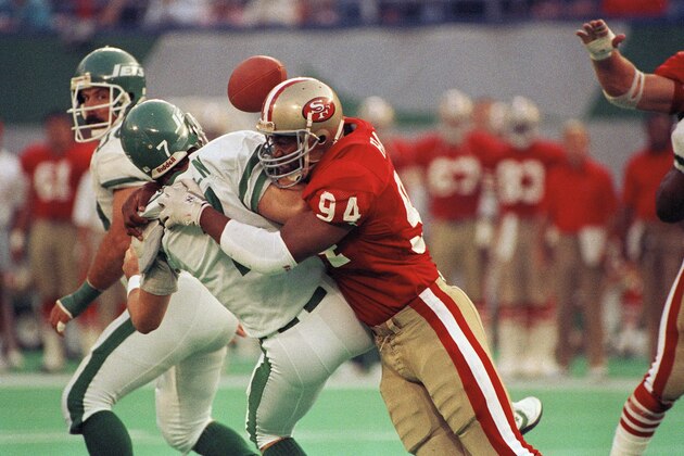 New York Jets quarterback Ken O'Brien is sacked by San Francisco 49ers Charles Haley in the first quarter of play in East Rutherford, N.J., Oct. 29, 1989. The 49ers recovered the ball after O'Brien fumbled on the play. (AP Photo/Bill Kostroun)
