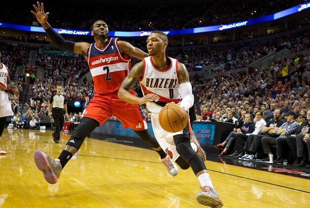 Mar 20, 2014; Portland, OR, USA;  Portland Trail Blazers guard Damian Lillard (0) dribbles the ball around Washington Wizards guard John Wall (2) in the second half at Moda Center. Mandatory Credit: Jaime Valdez-USA TODAY Sports