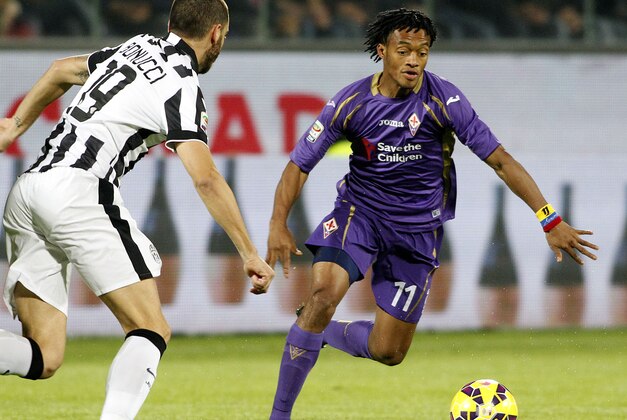 Fiorentina's Juan Guillermo Cuadrado  is challenged by Juventus' Leonardo Bonucci during a Serie A soccer match at the Artemio Franchi stadium in Florence, Italy,  Friday, Dec.. 5  2014. (AP Photo/Fabrizio Giovannozzi)