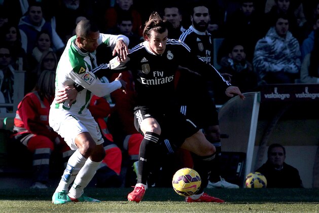 Real Madrid's Gareth Bale, right, and Cordoba's Edimar Fraga fight for the ball during their La Liga soccer match at the Arcangel stadium, in Cordoba, Spain on Saturday, Jan. 24, 2015. (AP Photo/Miguel Morenatti)