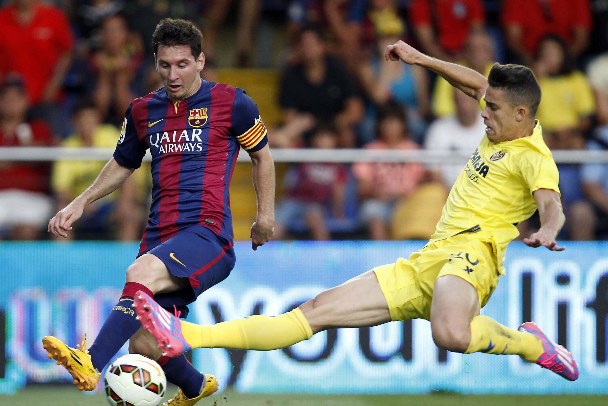 Barcelona's Lionel Messi, from Argentina, challenges for the ball with Villarreal's Grabiel Paulista from Brazil  during a Spanish La Liga soccer match at the Madrigal stadium in Villarreal, Spain, on Sunday, Aug 31, 2014.(AP Photo/Alberto Saiz)