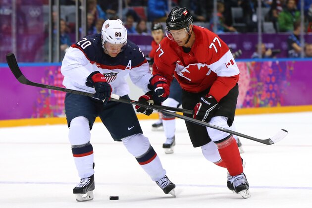 SOCHI, RUSSIA - FEBRUARY 21:  Ryan Suter #20 of the United States crosses sticks with Jeff Carter #77 of Canada during the Men's Ice Hockey Semifinal Playoff on Day 14 of the 2014 Sochi Winter Olympics at Bolshoy Ice Dome on February 21, 2014 in Sochi, Russia.  (Photo by Martin Rose/Getty Images)