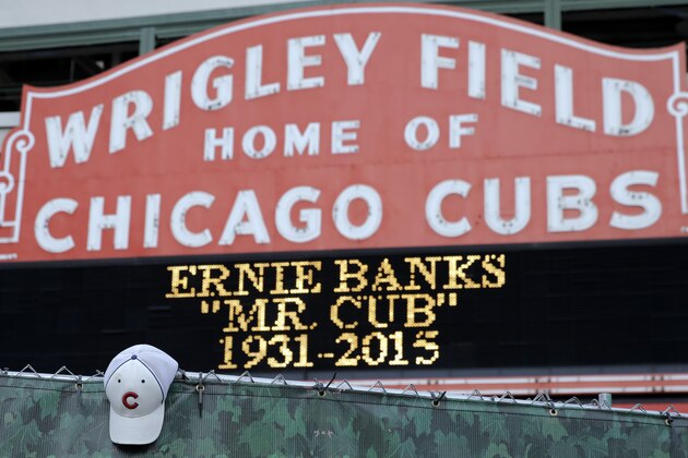 A Chicago Cubs hat hangs on the construction fence in front of Wrigley Field in honor of Ernie Banks in Chicago, Saturday, Jan. 24, 2014. Chicago Cubs legend Ernie Banks has died at the age of 83. 'Mr. Cub' passed away Friday night at Northwestern Memorial Hospital in Chicago.(AP Photo/Nam Y. Huh)