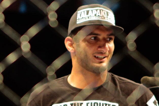 Gegard Mousasi, left, receives applause after  he defats Mark Munoz from the United States  in a middleweight fight during the UFC Fight Night mixed martial arts event in Berlin, Saturday, May 31, 2014. (AP Photo/Markus Schreiber)