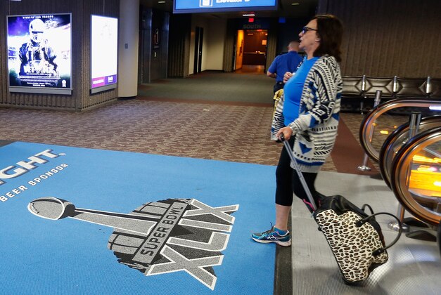 PHOENIX, AZ - JANUARY 19:  Travelers walk past Super Bowl XLIX logos at Phoenix Sky Harbor International Airport on January 19, 2015 in Phoenix, Arizona. The NFL Super Bowl XLIX will be held at the University of Phoenix Stadium on Febrauary 1, 2015.  (Photo by Christian Petersen/Getty Images)