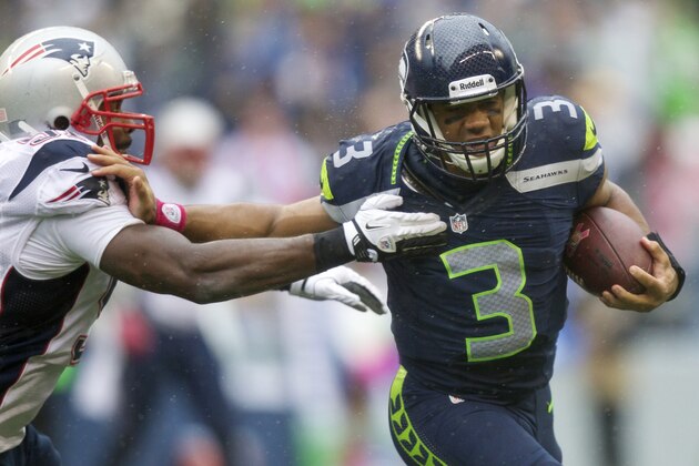 SEATTLE, WA - OCTOBER 14: Russell Wilson #3 of the Seattle Seahawks rushes the ball against the Jerod Mayo #51 of the New England Patriots during a game at CenturyLink Field on October 14, 2012 in Seattle, Washington. The Seahawks beat the Patriots 24-23.  (Photo by Stephen Brashear/Getty Images)