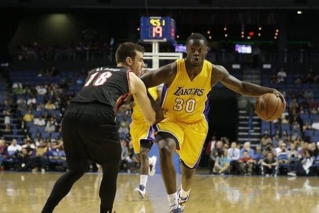 Los Angeles Lakers' Julius Randle, right, drives on Portland Trail Blazers' Victor Claver during the first half of a preseason NBA basketball game Wednesday, Oct. 22, 2014, in Ontario, Calif. (AP Photo/Jae C. Hong)