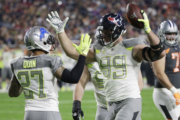 Houston Texans' J.J. Watt (99) is congratulated by Detroit Lions' Glover Quin after intercepting a pass during the first half of the NFL Football Pro Bowl Sunday, Jan. 25, 2015, in Glendale, Ariz.  (AP Photo/David J. Phillip)