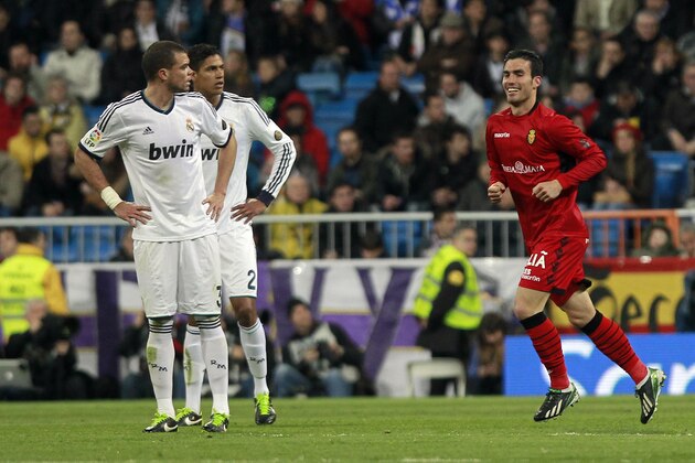 Mallorca's Alejandro Alfaro, right, celebrates his goal beside Real Madrid's Pepe from Portugal, left, and Raphael Varane from France, during a Spanish La Liga soccer match at the Santiago Bernabeu stadium in Madrid, Spain, Saturday, March 16, 2013. (AP Photo/Andres Kudacki)