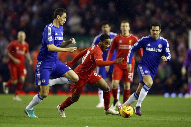 Liverpool's Raheem Sterling, center, runs with the ball  during the English League Cup semi-final first leg soccer match between Liverpool and Chelsea at Anfield Stadium, Liverpool, England, Tuesday Jan. 20, 2015. (AP Photo/Jon Super)