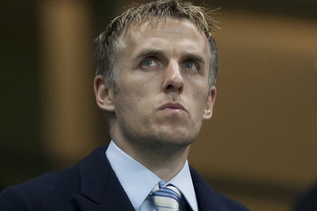 Manchester United coach Phil Neville takes his seat before Manchester City's English FA Cup third round replay soccer match against  Blackburn at The City of Manchester Stadium, Manchester, England, Wednesday, Jan. 15, 2014. (AP Photo/Jon Super)
