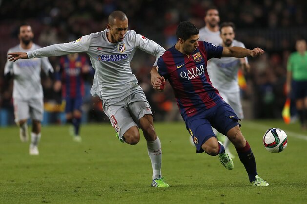 Barcelona's Luis Suarez, from Uruguay, right, fights for the ball against Atletico's Joao Miranda during a Copa del Rey Quarterfinal soccer match between FC Barcelona and Atletico Madrid, at the Camp Nou stadium in Barcelona, Spain, Wednesday, Jan. 21, 2015. (AP Photo/Emilio Morenatti)