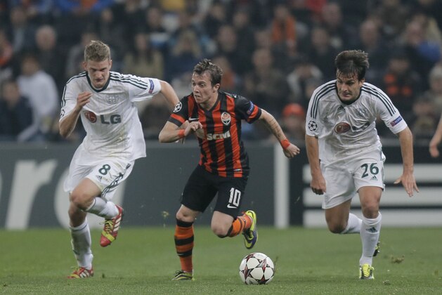 Donetsk's Bernard, center, Leverkusen's Lars Bender, left, and fellow team member Giulio Donati challenge for the ball during the Champions League group A soccer match between Bayer 04 Leverkusen and FC Shakhtar Donetsk at the Donbas Arena stadium in Donetsk, Ukraine, Tuesday, Nov. 5, 2013. (AP Photo/Efrem Lukatsky)