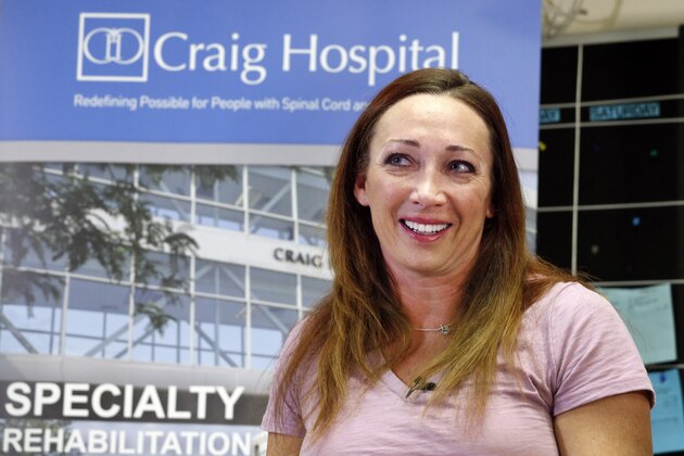 Olympic swimmer Amy Van Dyken-Rouen talks with members of the media as she leaves Craig Hospital in Englewood, Colo., Thursday, Aug. 14, 2014. Van Dyken-Rouen was left paralyzed just below the waist in an all-terrain vehicle crash on June 6 in Arizona. (AP Photo/Brennan Linsley)