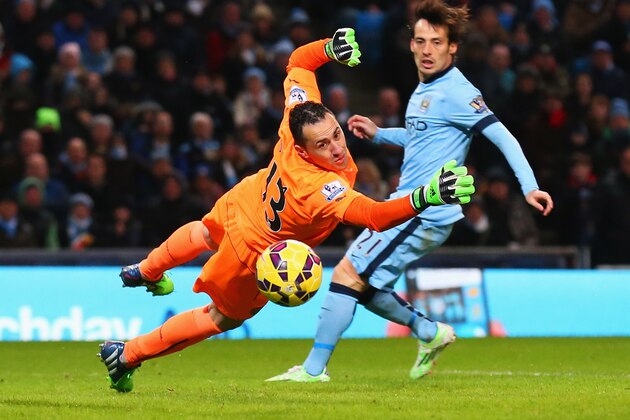 MANCHESTER, ENGLAND - JANUARY 18:  David Ospina of Arsenal diuves as David Silva of Manchester City looks on during the Barclays Premier League match between Manchester City and Arsenal at Etihad Stadium on January 18, 2015 in Manchester, England.  (Photo by Alex Livesey/Getty Images)