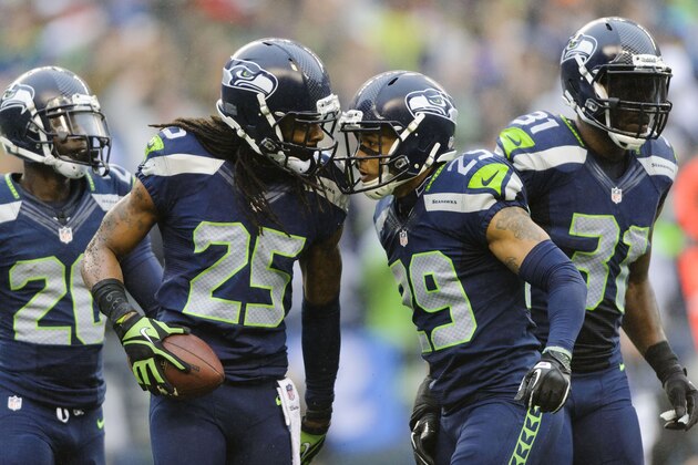 Dec 22, 2013; Seattle, WA, USA; Seattle Seahawks cornerback Richard Sherman (25) and free safety Earl Thomas (29) celebrate after Sherman intercepted the ball thrown by Arizona Cardinals quarterback Carson Palmer (not pictured) during the game at CenturyLink Field. Arizona defeated Seattle 17-10. Mandatory Credit: Steven Bisig-USA TODAY Sports