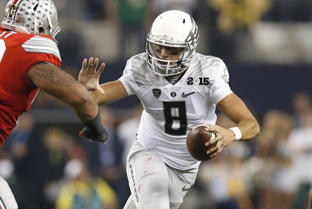 Jan 12, 2015; Arlington, TX, USA; Oregon Ducks quarterback Marcus Mariota (8) scrambles against Ohio State Buckeyes defensive tackle Michael Bennett (53) in the 2015 CFP National Championship Game at AT&T Stadium. Mandatory Credit: Matthew Emmons-USA TODAY Sports