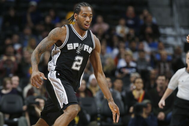 San Antonio Spurs forward Kahwi Leonard pursues a loose ball against the Denver Nuggets in the fourth quarter of an NBA basketball game on Sunday, Dec. 14, 2014, in Denver. San Antonio defeated Denver 99-91. (AP Photo/David Zalubowski)