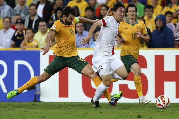 China's Ren Hang, centre, takes the ball past Australia's Mile Jedinak, left, and Robbie Kruse during the AFC Asia Cup quarterfinal soccer match between China and Australia in Brisbane, Australia, Thursday, Jan. 22, 2015. (AP Photo/Tertius Pickard)