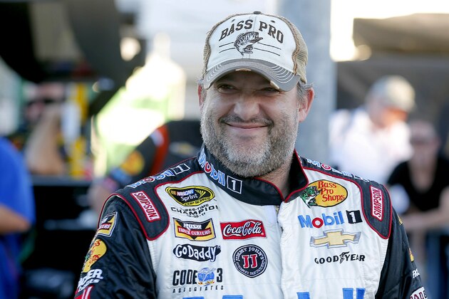 Tony Stewart grins before qualifying for a NASCAR Sprint Cup Series auto race at Phoenix International Raceway in Avondale, Ariz,. Friday, Nov. 7, 2014. (AP Photo/Rick Scuteri)