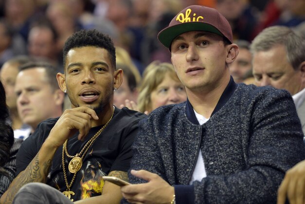 Oct 30, 2014; Cleveland, OH, USA; Cleveland Browns cornerback Joe Haden (left) and quarterback Johnny Manziel watch from the front row in the second quarter of a game between the Cleveland Cavaliers and the New York Knicks at Quicken Loans Arena. New York won 95-90. Mandatory Credit: David Richard-USA TODAY Sports