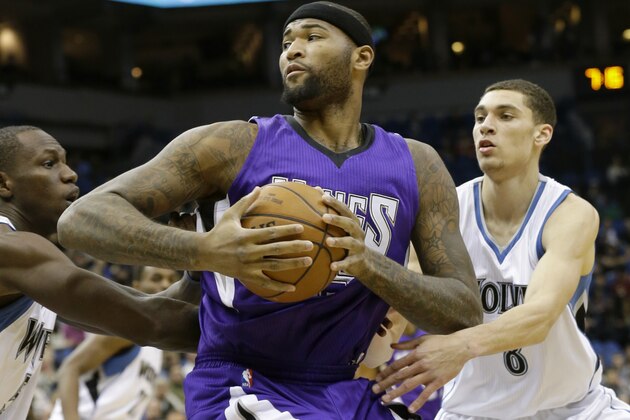 Sacramento Kings center DeMarcus Cousins, center, splits the defense of Minnesota Timberwolves center Gorgui Dieng, left, of Senegal, and guard Zach LaVine, right, during the first quarter of an NBA basketball game in Minneapolis, Thursday, Jan. 1, 2015. The Kings won 110-107. (AP Photo/Ann Heisenfelt)