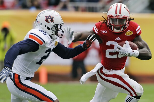 Wisconsin running back Melvin Gordon (25) stiff arms Auburn defensive back Johnathan Ford (23) on a run during the second quarter of the Outback Bowl NCAA college football game, Thursday, Jan. 1, 2015, in Tampa, Fla. (AP Photo/Chris O'Meara)