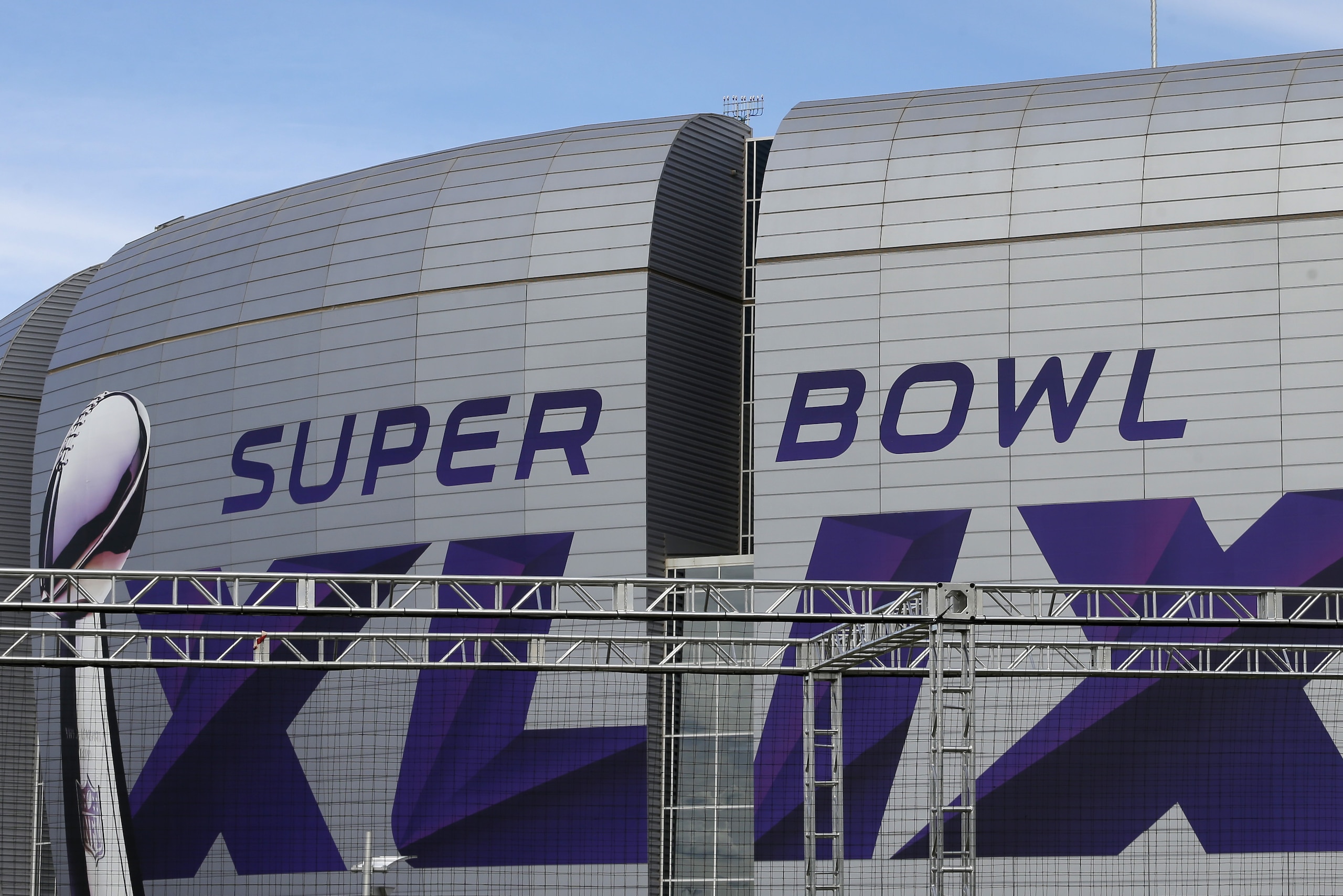 A worker hangs a light on an attraction outside the University of Phoenix Stadium as preparations continue for Super Bowl XLIX Wednesday, Jan. 28, 2015, in Glendale, Ariz. The New England Patriots face the Seattle Seahawks in the game on Sunday, Feb. 1, 2015, in Glendale, Ariz. (AP Photo/Charlie Riedel)