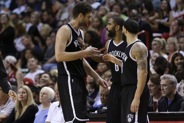 Brooklyn Nets center Brook Lopez, left, talks with Alan Anderson (6) and Deron Williams, right, during the second half of an NBA basketball game against the Miami Heat, Sunday, Jan. 4, 2015, in Miami. The Heat defeated the Nets 88-84. (AP Photo/Lynne Sladky)