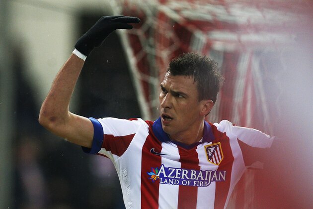 Atletico's Mario Mandzukic, centre, celebrates his goal during a Spanish La Liga soccer match between Atletico Madrid and Granada at the Vicente Calderon stadium in Madrid, Spain, Sunday, Jan. 18, 2015. (AP Photo/Andres Kudacki)
