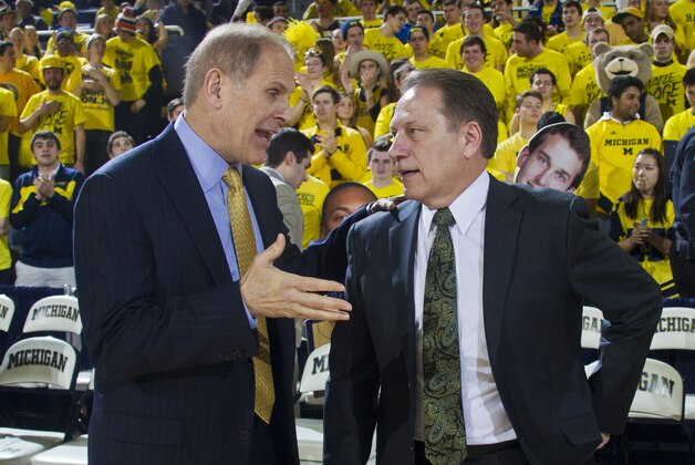 Michigan head coach John Beilein, left, talks with Michigan State head coach Tom Izzo, right, before the first half of an NCAA college basketball game at Crisler Center in Ann Arbor, Mich., Sunday, Feb. 23, 2014. (AP Photo/Tony Ding)