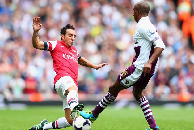 LONDON, ENGLAND - AUGUST 17:  Santi Cazorla of Arsenal and Fabian Delph of Aston Villa battle for the ball during the Barclays Premier League match between Arsenal and Aston Villa at Emirates Stadium on August 17, 2013 in London, England.  (Photo by Clive Mason/Getty Images)