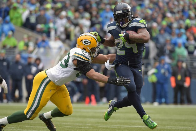 Jan 18, 2015; Seattle, WA, USA; Seattle Seahawks running back Marshawn Lynch (24) carries the ball as Green Bay Packers outside linebacker Nick Perry (53) attempts the tackle during the third quarter in the NFC Championship Game at CenturyLink Field. Mandatory Credit: Kirby Lee-USA TODAY Sports