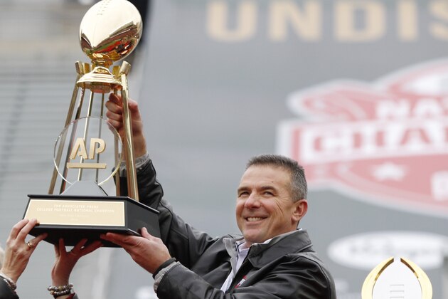 Ohio State coach Urban Meyer, right, and The Associated Press' east regional director Eva Parziale hold up The Associated Press college football national championship trophy during a celebration of the Buckeye's 2014 College Football Playoff national champion  at Ohio Stadium in Columbus, Ohio, Saturday, Jan. 24, 2015. (AP Photo/Paul Vernon)
