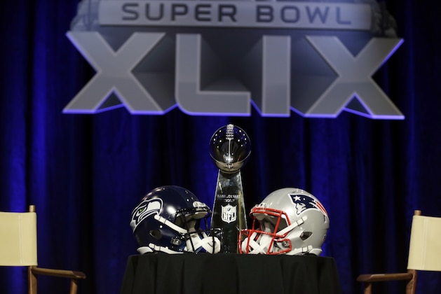 The Lombardi Trophy sits behind two helmets before a joint coaches news conference for NFL Super Bowl XLIX football game Friday, Jan. 30, 2015, in Phoenix. (AP Photo/David J. Phillip)