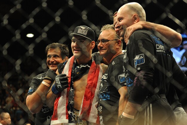 Jul 6, 2013; Las Vegas, NV, USA;  Chris Weldman (blue shorts) in the cage with his corner after defeating Anderson Silva during their Middleweight Chamionship Bout at the MGM Grand Garden Arena. Chris Weidman defeated Anderson in a TKO in the second round. Mandatory Credit: Jayne Kamin-Oncea-USA TODAY Sports