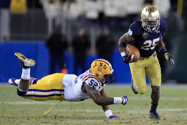 Notre Dame running back Tarean Folston (25) gets past LSU linebacker Kendell Beckwith (52) during the second half of the Music City Bowl NCAA college football game Tuesday, Dec. 30, 2014, in Nashville, Tenn. Notre Dame won 31-28. (AP Photo/Mark Humphrey)