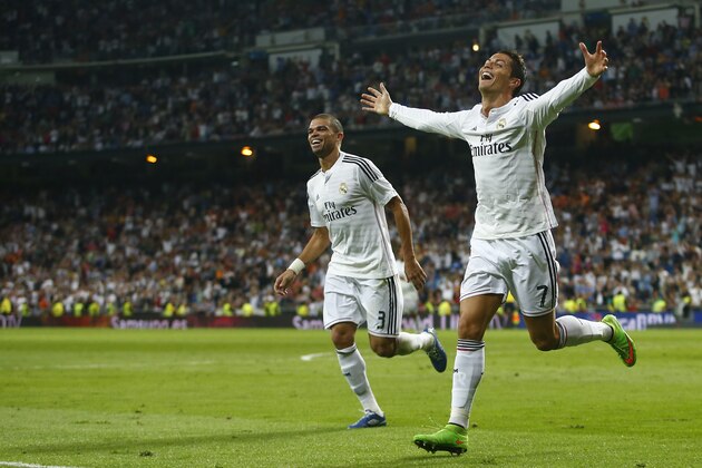 Real's Cristiano Ronaldo, right, celebrates his third goal with Pepe, left, during a Spanish La Liga soccer match between Real Madrid and Athletic Bilbao at the Santiago Bernabeu stadium in Madrid, Spain, Sunday, Oct. 5, 2014. (AP Photo/Andres Kudacki)