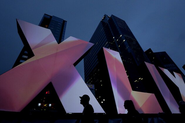 Fans look at Roman numerals for Super Bowl XLIX Friday Jan. 30, 2015, in downtown Phoenix. The Seattle Seahawks will play the New England Patriots in Super Bowl XLIX Sunday. (AP Photo/Charlie Riedel)