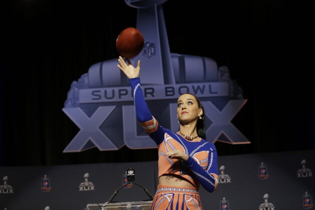 Katy Perry throws a football at a halftime news conference for NFL Super Bowl XLIX football game Thursday, Jan. 29, 2015, in Phoenix. (AP Photo/Morry Gash)