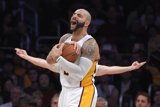 Los Angeles Lakers forward Carlos Boozer reacts as he gets called for a foul as referee Eli Roe gestures behind him during the second half of an NBA basketball game, Sunday, Jan. 11, 2015, in Los Angeles.  The Heat won 106-94. (AP Photo/Mark J. Terrill)