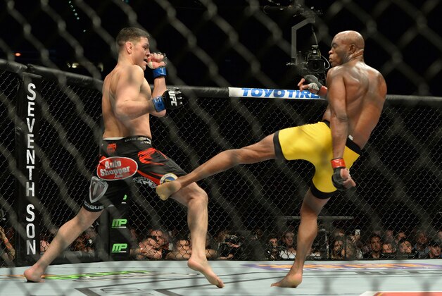 Jan 31, 2015; Las Vegas, NV, USA; Nick Diaz (blue gloves) is kicked by Anderson Silva (red gloves) during their middleweight bout during UFC 183 at the MGM Grand Garden Arena. Mandatory Credit: Jayne Kamin-Oncea-USA TODAY Sports