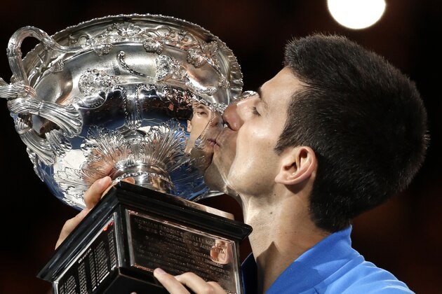Novak Djokovic of Serbia kisses the trophy after defeating Andy Murray of Britain in the men's singles final at the Australian Open tennis championship in Melbourne, Australia, Sunday, Feb. 1, 2015. (AP Photo/Vincent Thian)