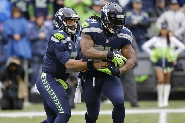 Seattle Seahawks quarterback Russell Wilson (3) hands off to Marshawn Lynch (24) during the first half of the NFL football NFC Championship game against the Green Bay Packers Sunday, Jan. 18, 2015, in Seattle. (AP Photo/Ted S. Warren)