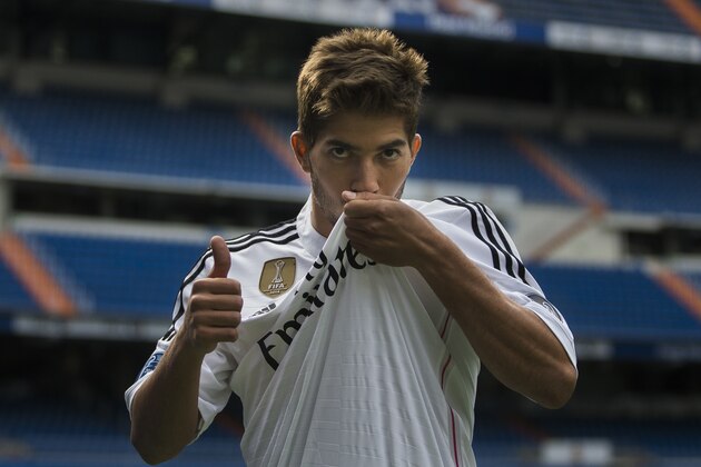 Brazil international soccer player Lucas Silva kisses his t-shirt as he poses during his official presentation at the Santiago Bernabeu stadium in Madrid, Spain, Monday, Jan. 26, 2015, after signing for Real Madrid. (AP Photo/Andres Kudacki)