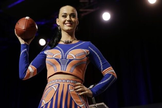 Katy Perry poses with a football at a news conference regarding the half time show for NFL Super Bowl XLIX football game Thursday, Jan. 29, 2015, in Phoenix. (AP Photo/David J. Phillip)