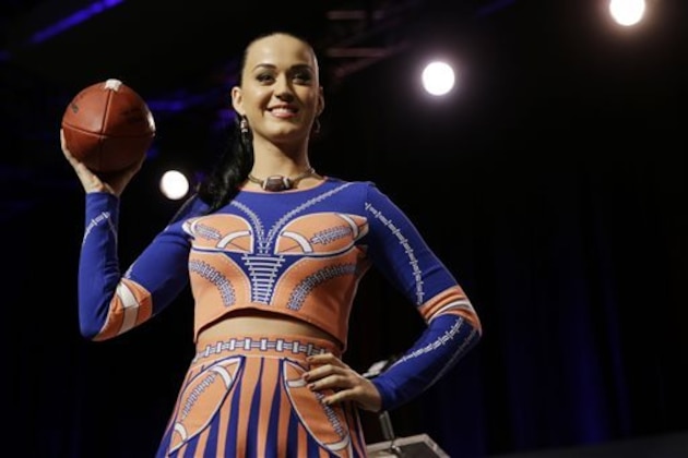 Katy Perry poses with a football at a news conference regarding the half time show for NFL Super Bowl XLIX football game Thursday, Jan. 29, 2015, in Phoenix. (AP Photo/David J. Phillip)