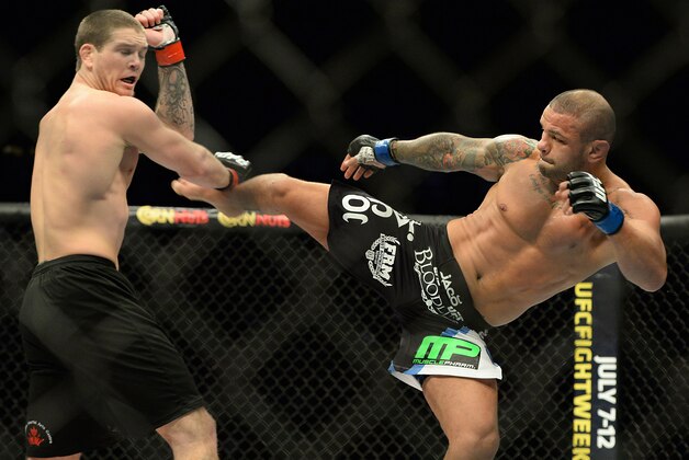 Jan 31, 2015; Las Vegas, NV, USA;  Jordan Mein (red gloves) blocks a kick from Thiago Alves (blue gloves) during their welterweight bout during UFC 183 at the MGM Grand Garden Arena. Mandatory Credit: Jayne Kamin-Oncea-USA TODAY Sports