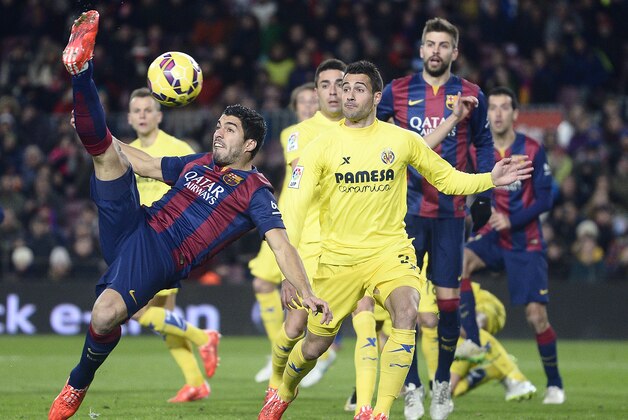 FC Barcelona's Luis Suarez, from Uruguay, left, in action against Villarreal's Mario Gaspar, second left, during a Spanish La Liga soccer match at the Camp Nou stadium in Barcelona, Spain, Sunday, Feb. 1, 2015. (AP Photo/Manu Fernandez)