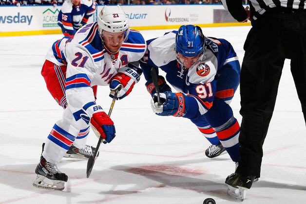 UNIONDALE, NY - JANUARY 27: John Tavares #91 of the New York Islanders battles for a faceoff with Derek Stepan #21 of the New York Rangers at Nassau Veterans Memorial Coliseum on January 27, 2015 in Uniondale, New York.  (Photo by Mike Stobe/NHLI via Getty Images)